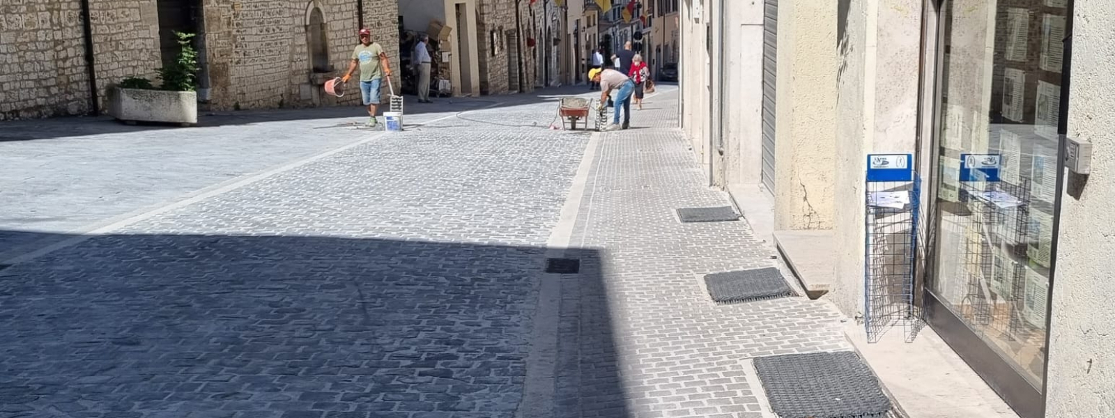 si vede un viale con delle persone che camminano sullo sfondo